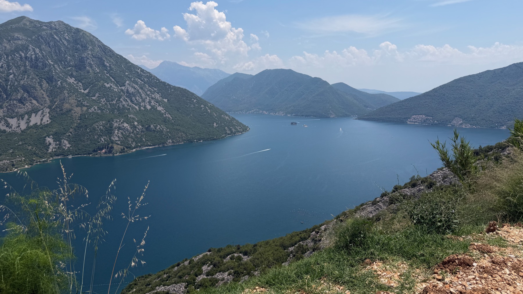 The Bay of Kotor seen from the mountainside, with boats crossing the water