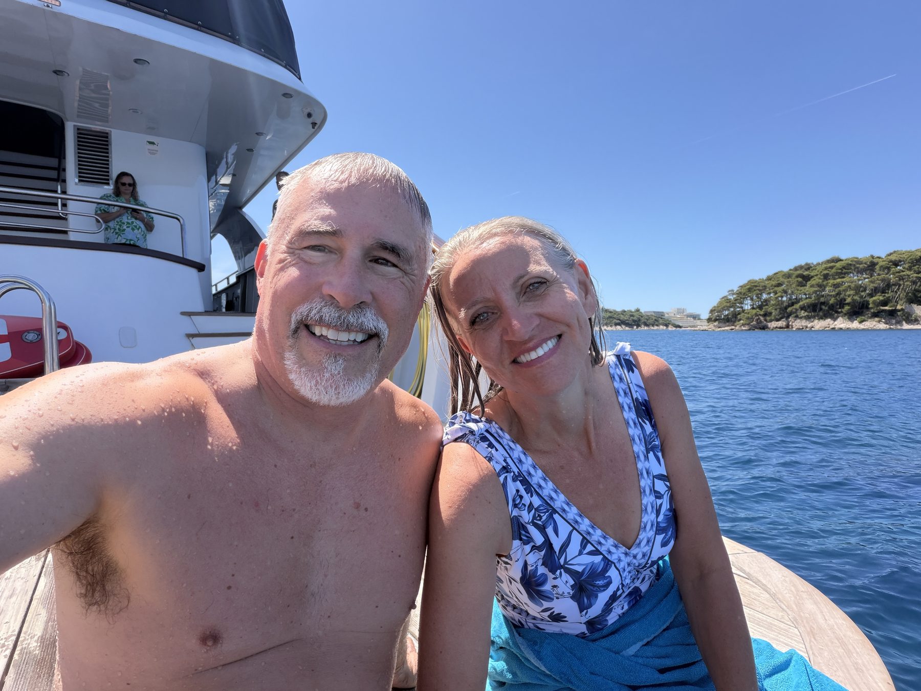 Chuck and Connie Holton aboard the boat after a swim, an Adriatic island behind them