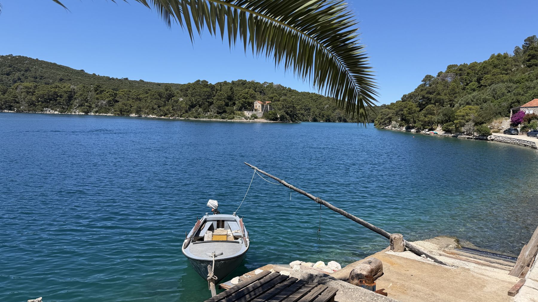 A quiet island bay with a small boat and stone chapel along the Dalmatian coast
