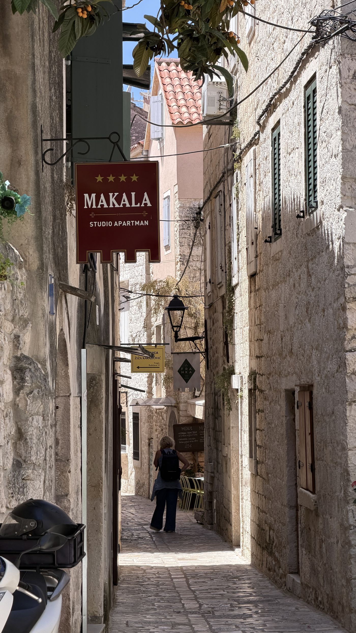 A narrow stone alley in a historic Dalmatian coastal town
