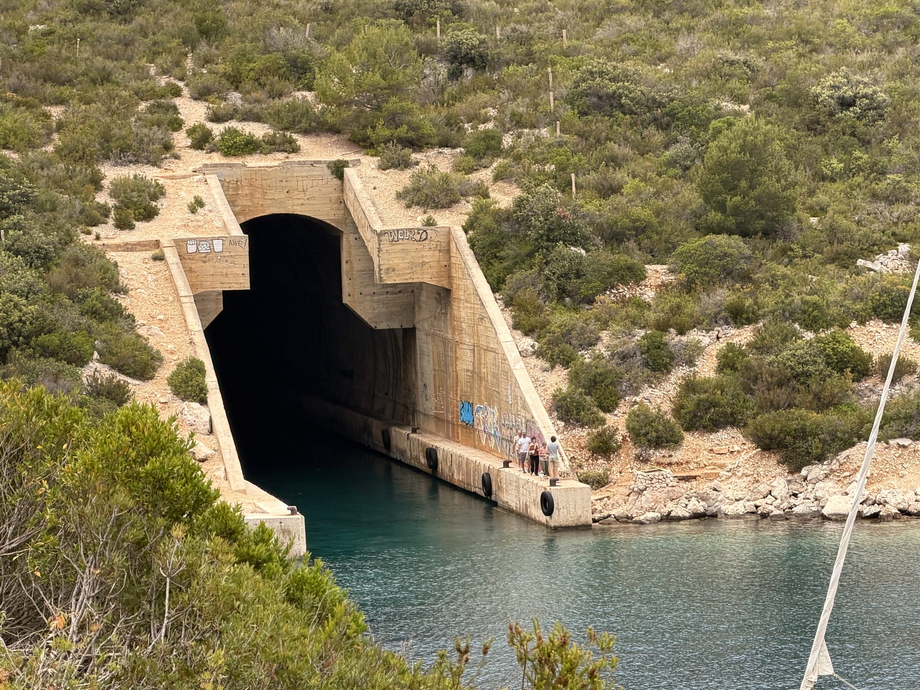 A former Yugoslav military boat tunnel cut into the hillside at the water's edge on Vis