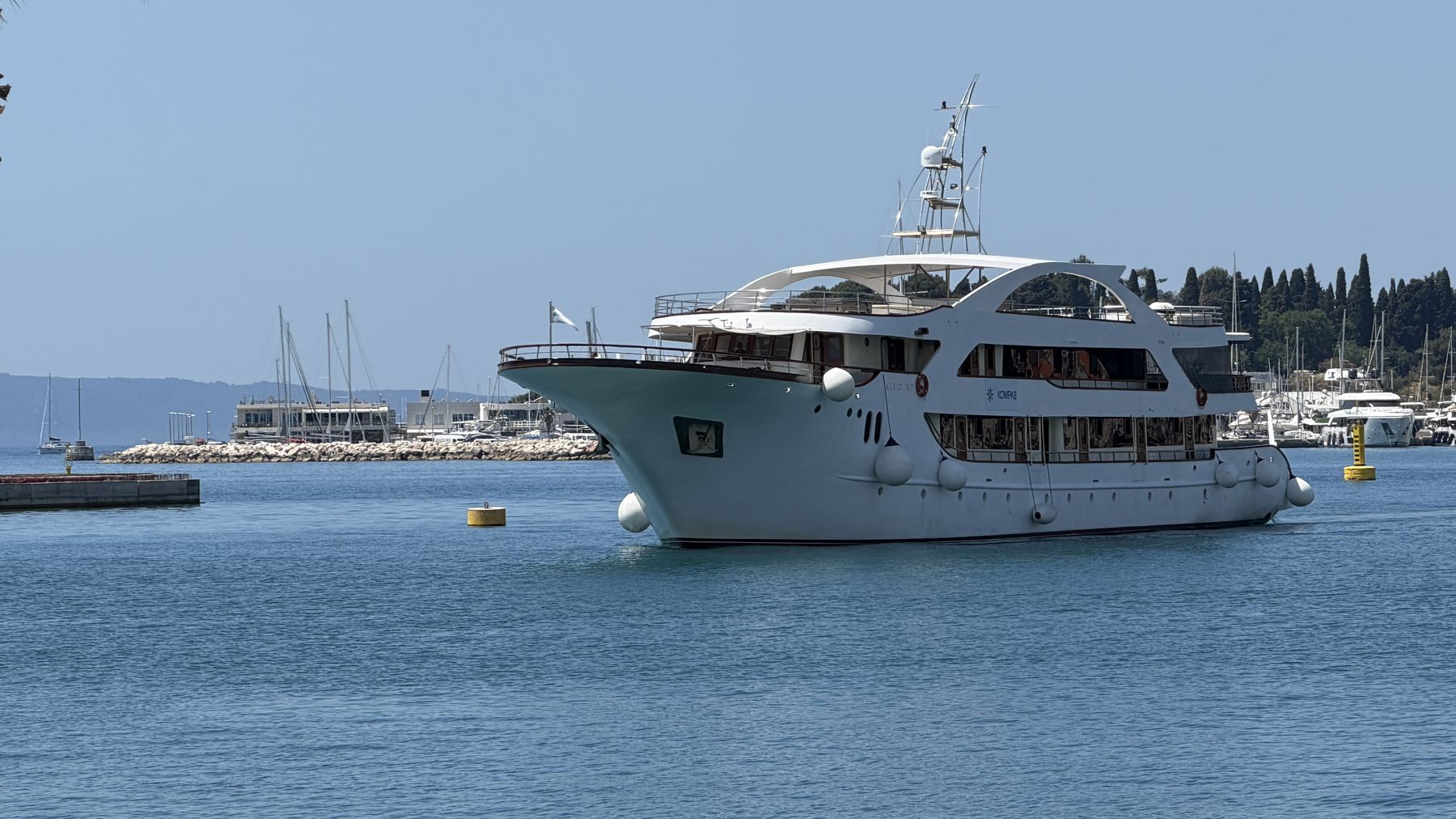 A small cruise yacht moored among boats in a Croatian harbor