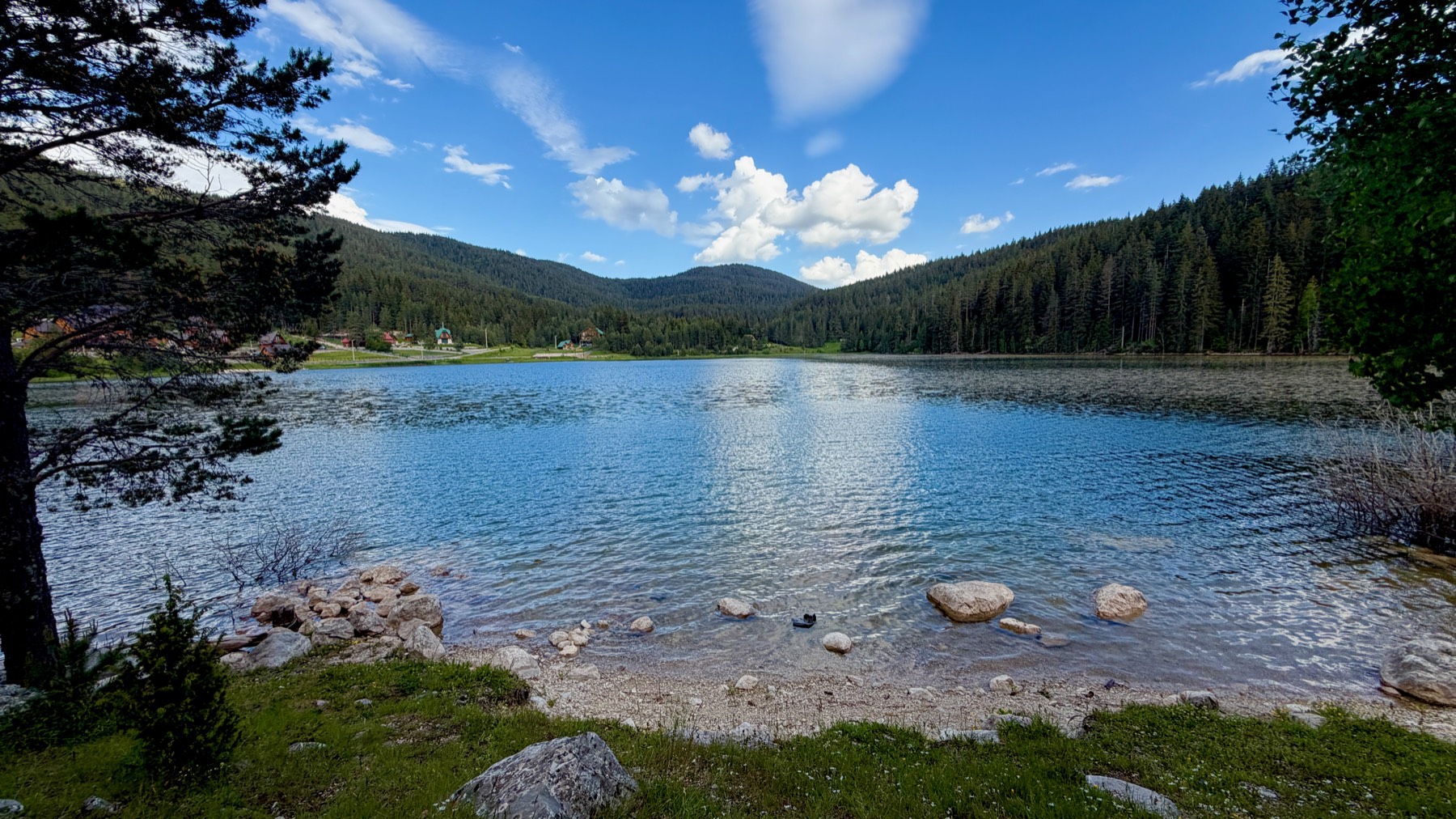 The lake at Etno Selo Zminica, ringed by pine forest, in Durmitor, Montenegro