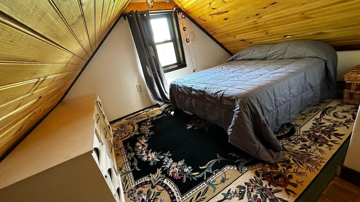 The upstairs bedroom at Apple Tree Cabin under the sloped pine ceiling